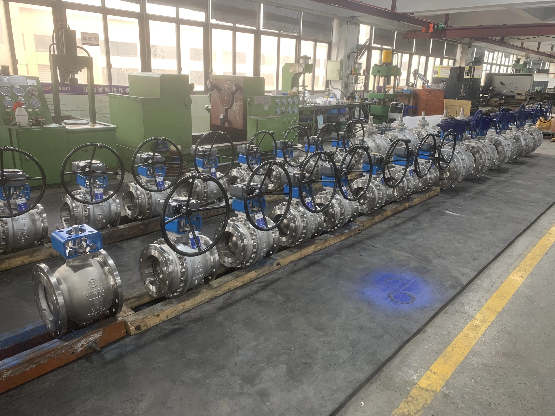 A long row of heavy-duty stainless steel flanged ball valves on the production floor at the BSO Valve manufacturing facility in Wenzhou.