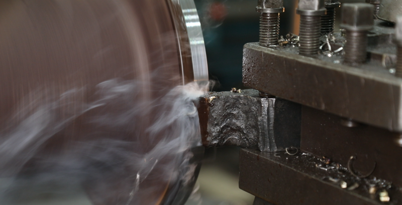 High-speed CNC lathe tool cutting raw metal to achieve micro-level precision for industrial valves