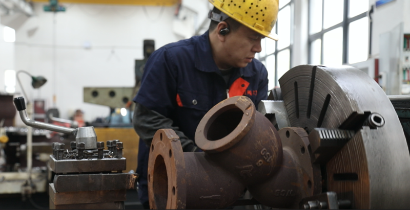 BSO Ballseal factory worker machining a heavy-duty cast steel valve body on a lathe in the manufacturing workshop.